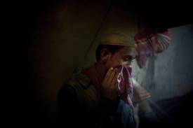 Workers without proper face protection sandblast denim at a plant outside of Dhaka, Bangladesh